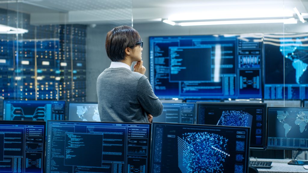 a man standing in the room with monitors